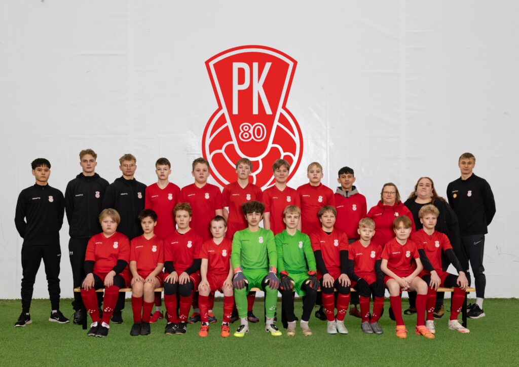 Mikkelin Pallo-Kissojen P14 juniorit iloisina joukkuekuvassa. Pelaajilla on joukkueen punainen peliasu.