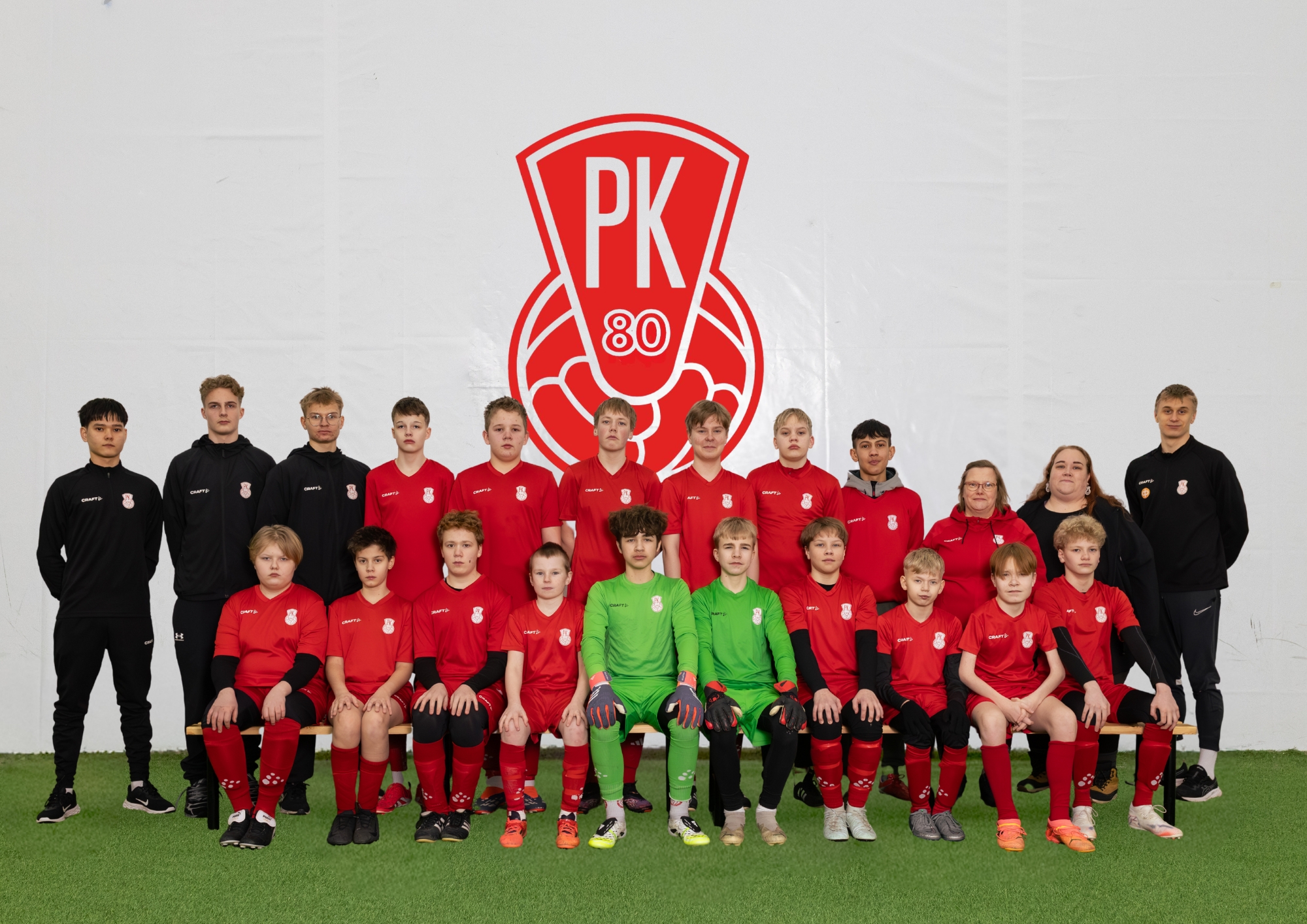 Mikkelin Pallo-Kissojen P14 juniorit iloisina joukkuekuvassa. Pelaajilla on joukkueen punainen peliasu.